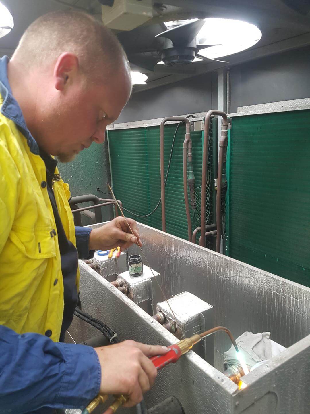 Man in uniform fixing a chiller