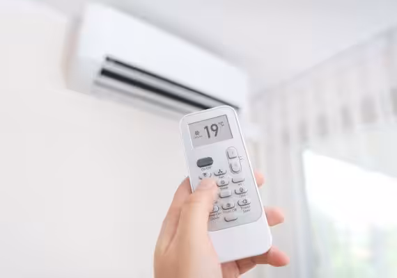 Someone holding a remote for an air conditioner