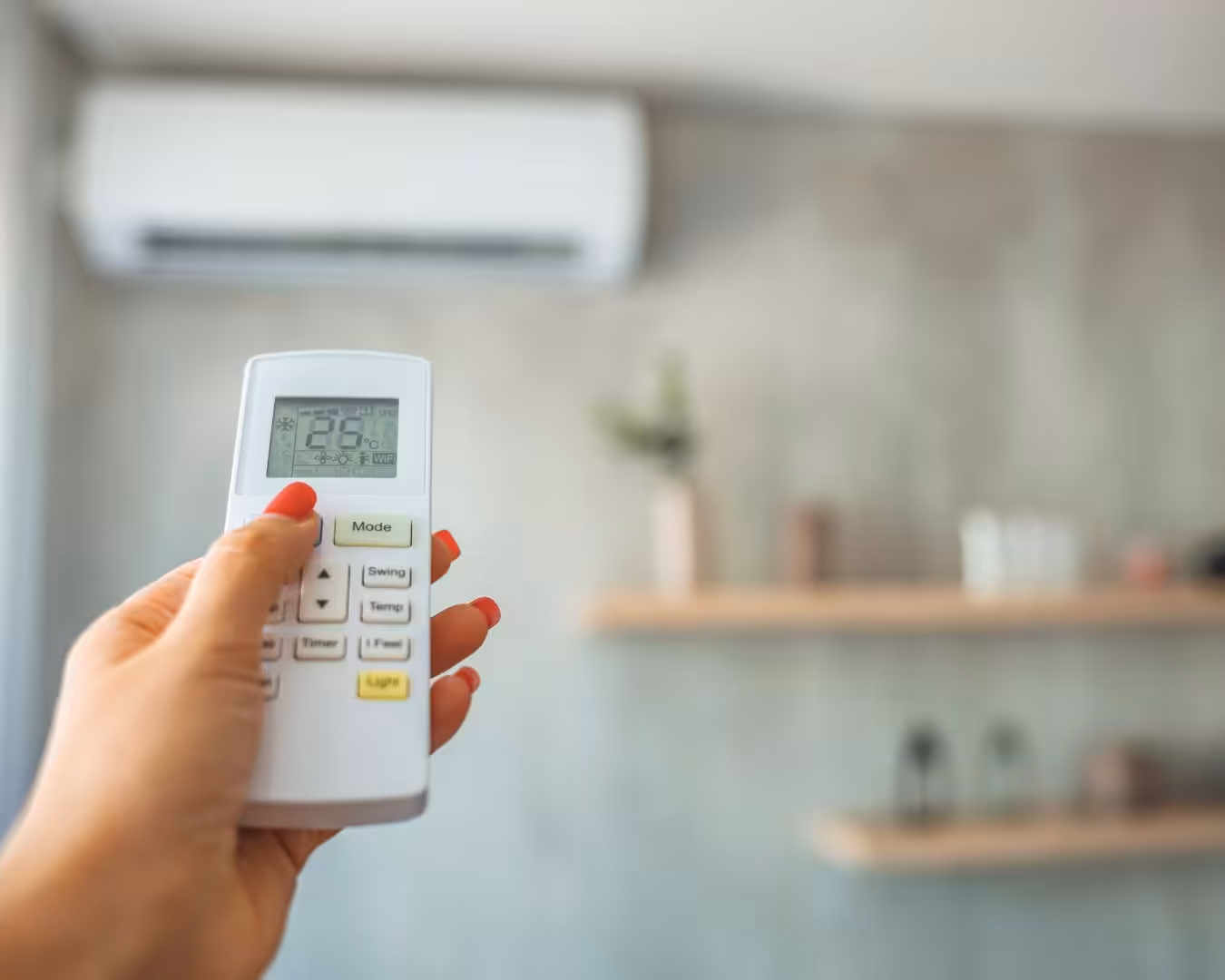 Someone holding a remote for an air conditioner