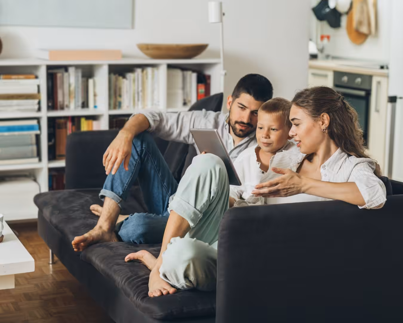 Family of three discussing and watching on a tablet