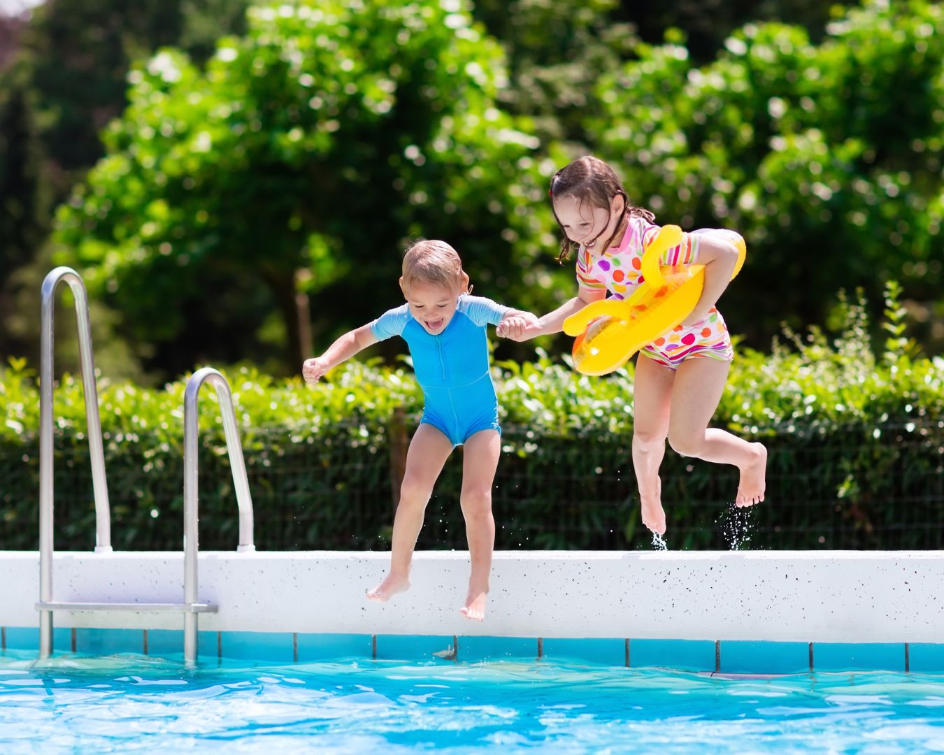 Two kids jumping in a pool