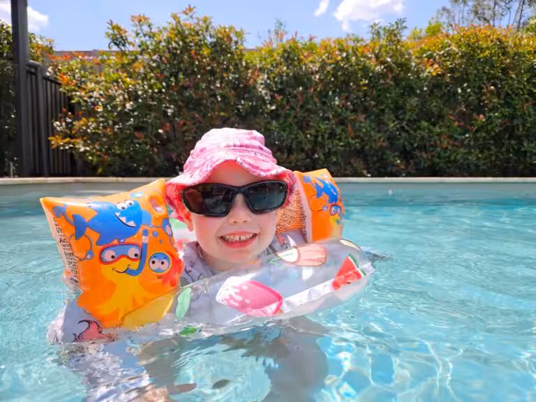 Happy child swimming in a pool during summer